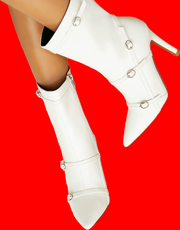 White knee-high boots with silver buckles on a red background